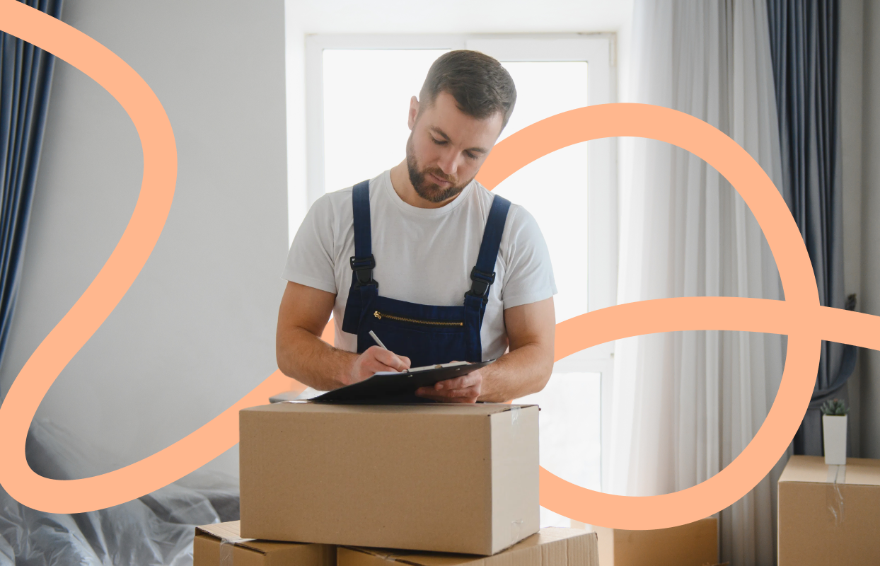 Removal professional completing paperwork beside moving boxes during a house move.