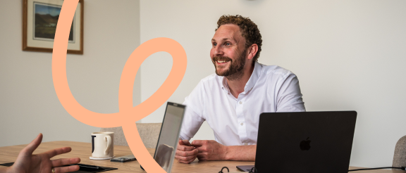 Konnect You team member speaking with colleagues in a meeting.